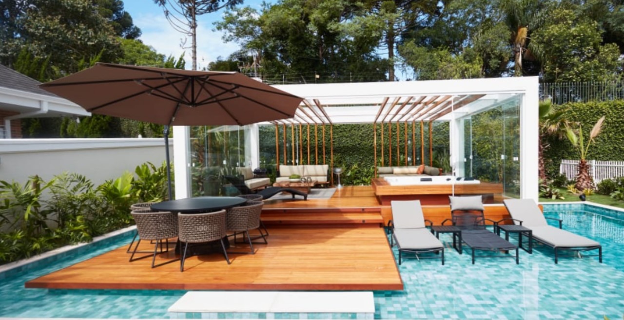 Área de piscina com um lindo deck de madeira nobre Cumaru