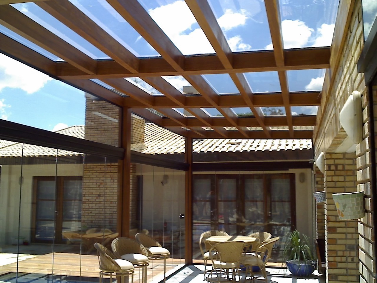 Pergolado de madeira robusto em área externa ajardinada